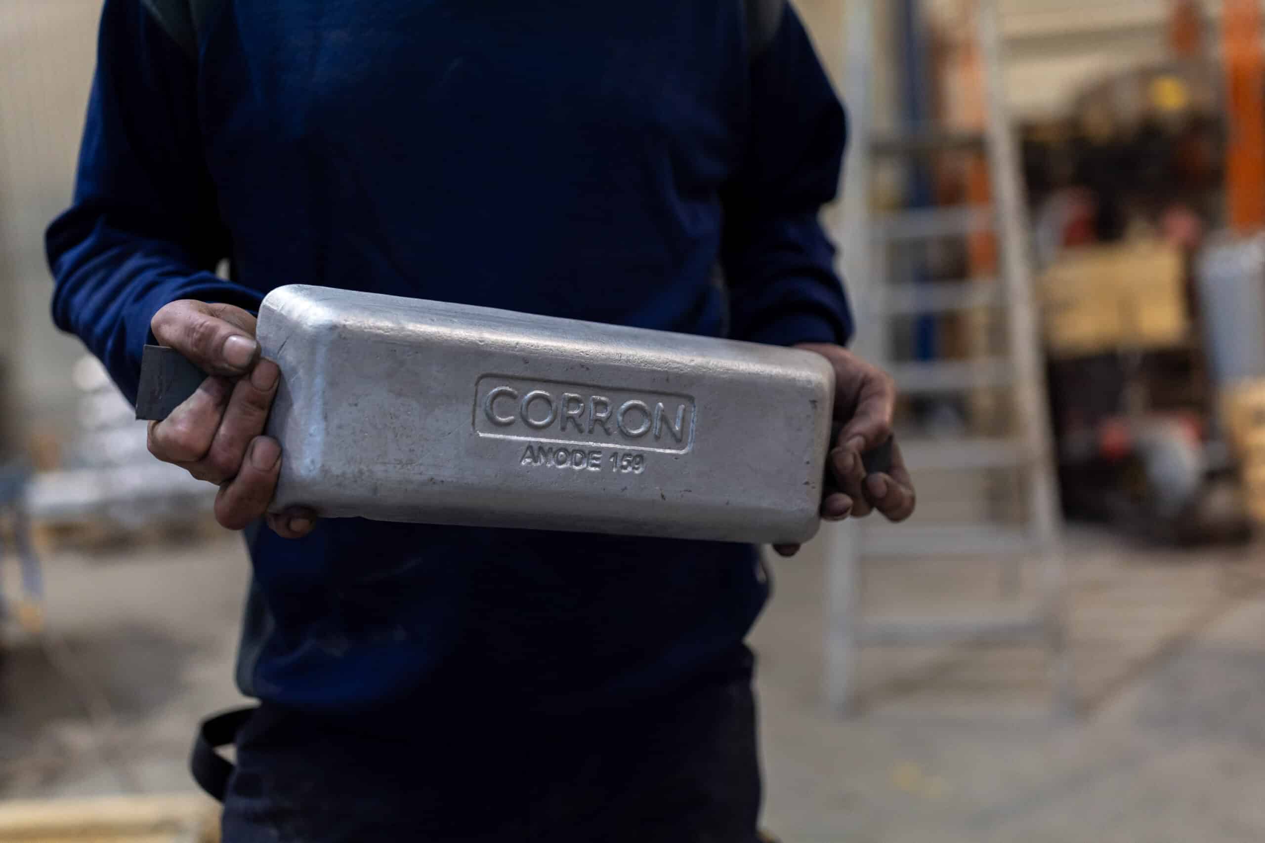 En operatør holder en aluminiumsanode